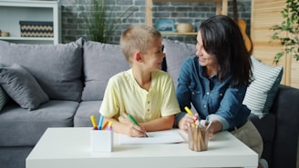 Mother and son drawing at a table together.