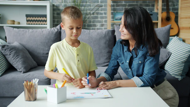 Mother and son drawing together at a table.