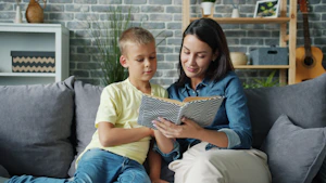 Mother and son reading a book together on sofa.