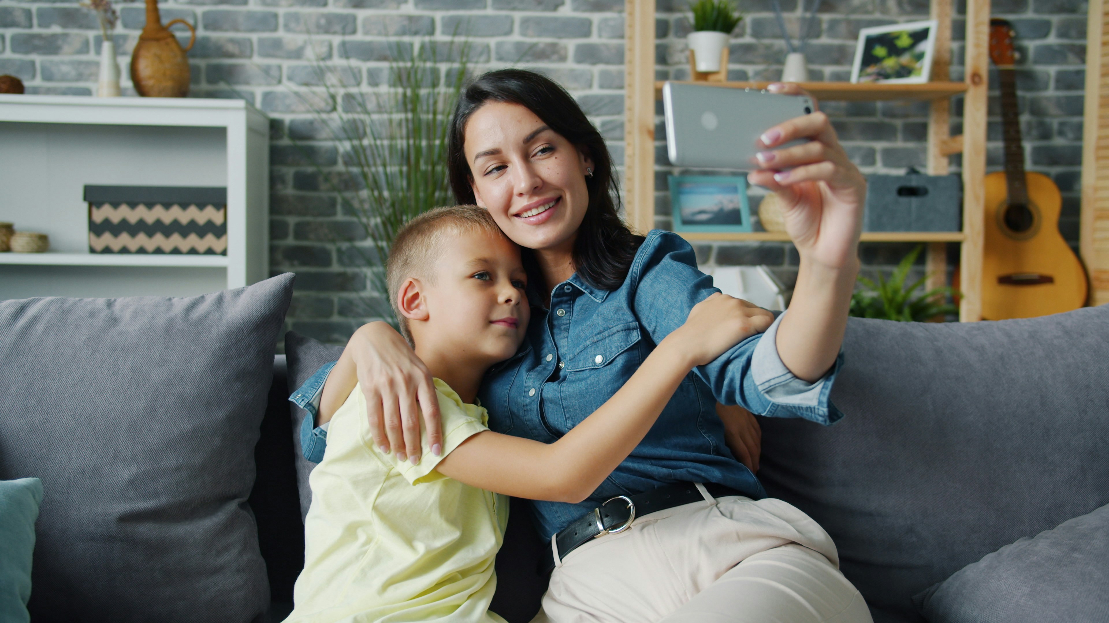 Mother and son taking a selfie on the couch.