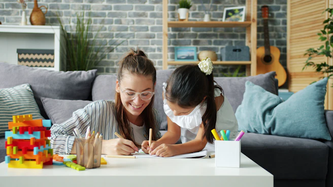 Woman and child drawing together on a couch.