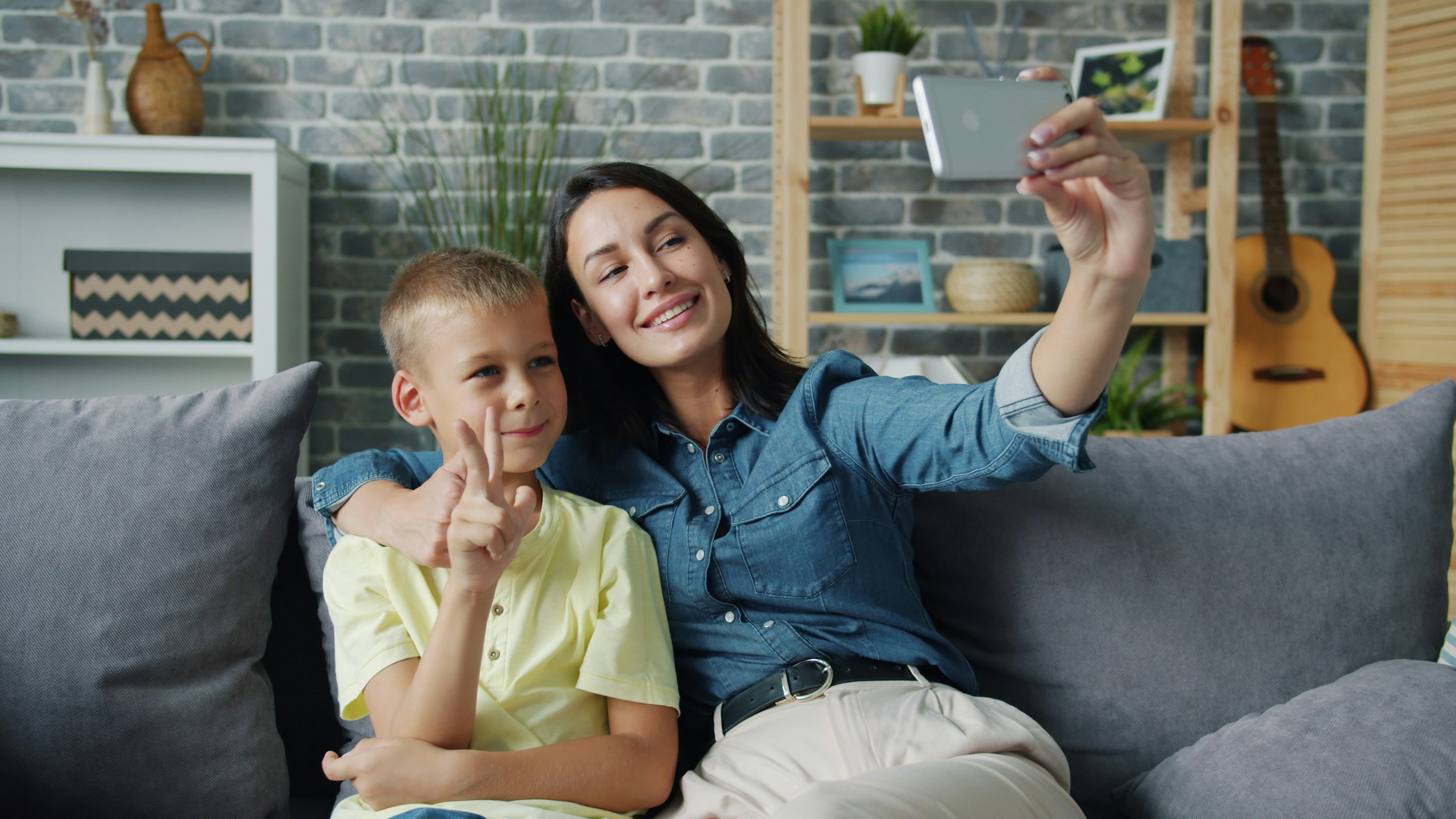 Mother and son taking a selfie on the couch.
