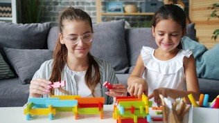 Woman and child building with colorful blocks