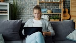 Young woman working on laptop on couch