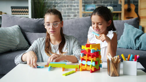 Two children building with colourful blocks at a table