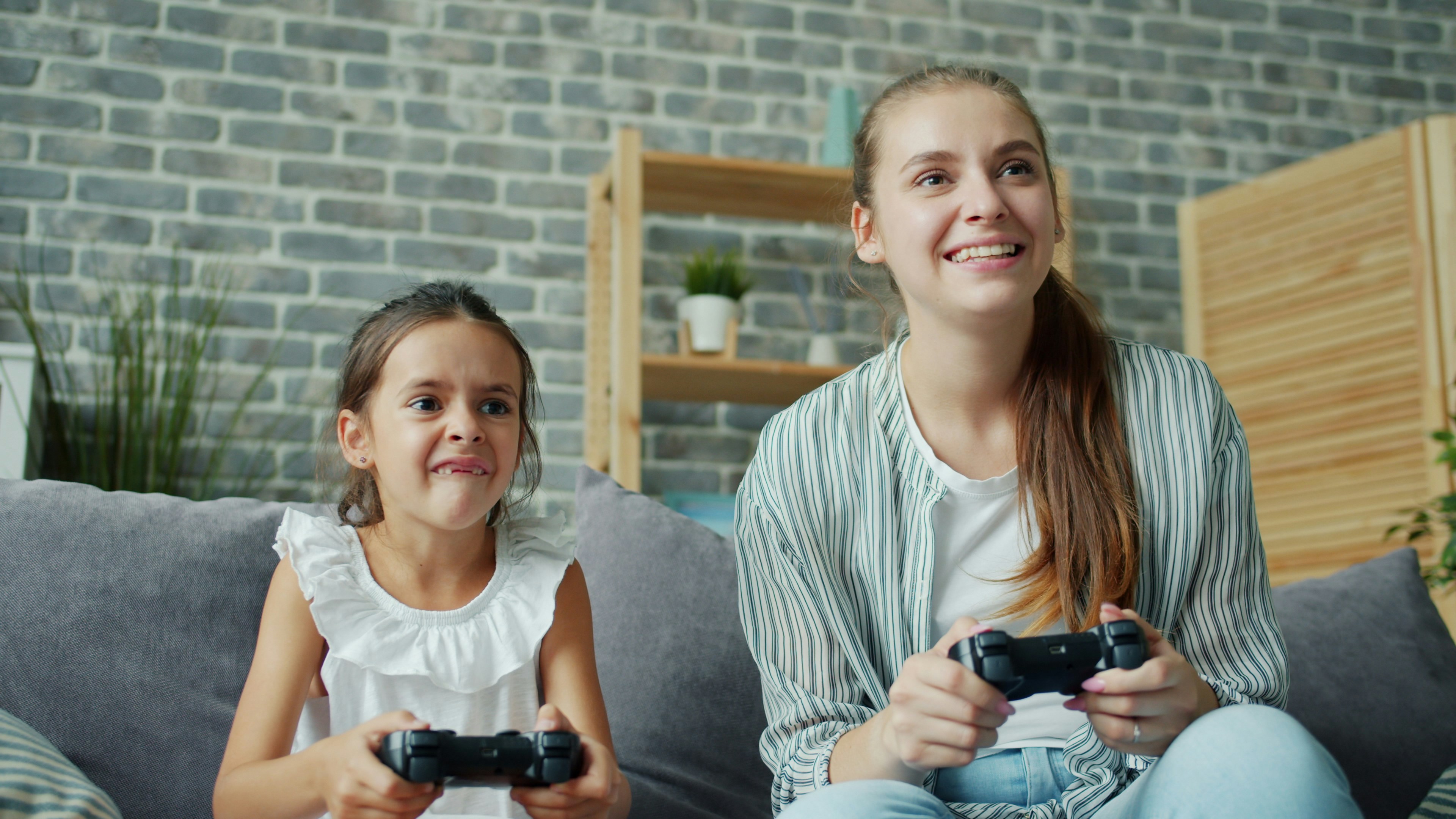 Mother and daughter playing video games together