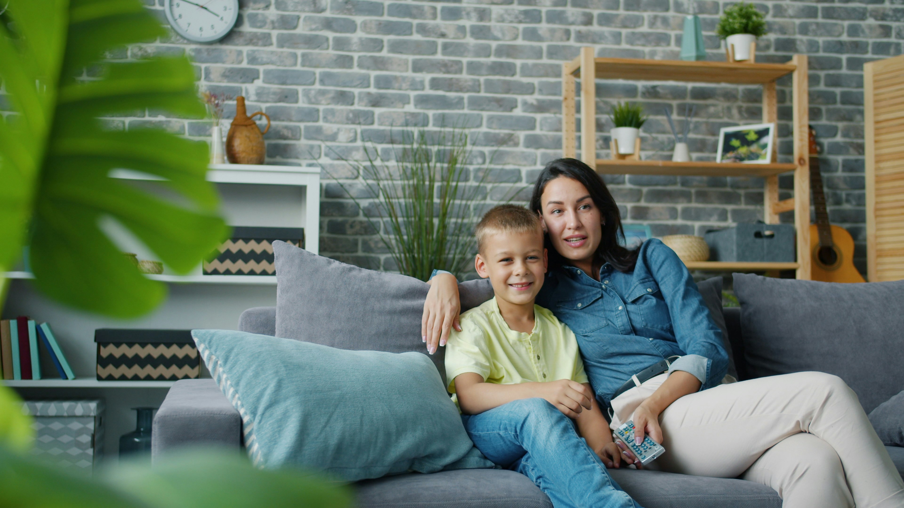 Mother and son sitting on a couch together.