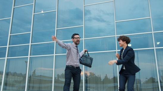Two business people celebrating outside modern office building