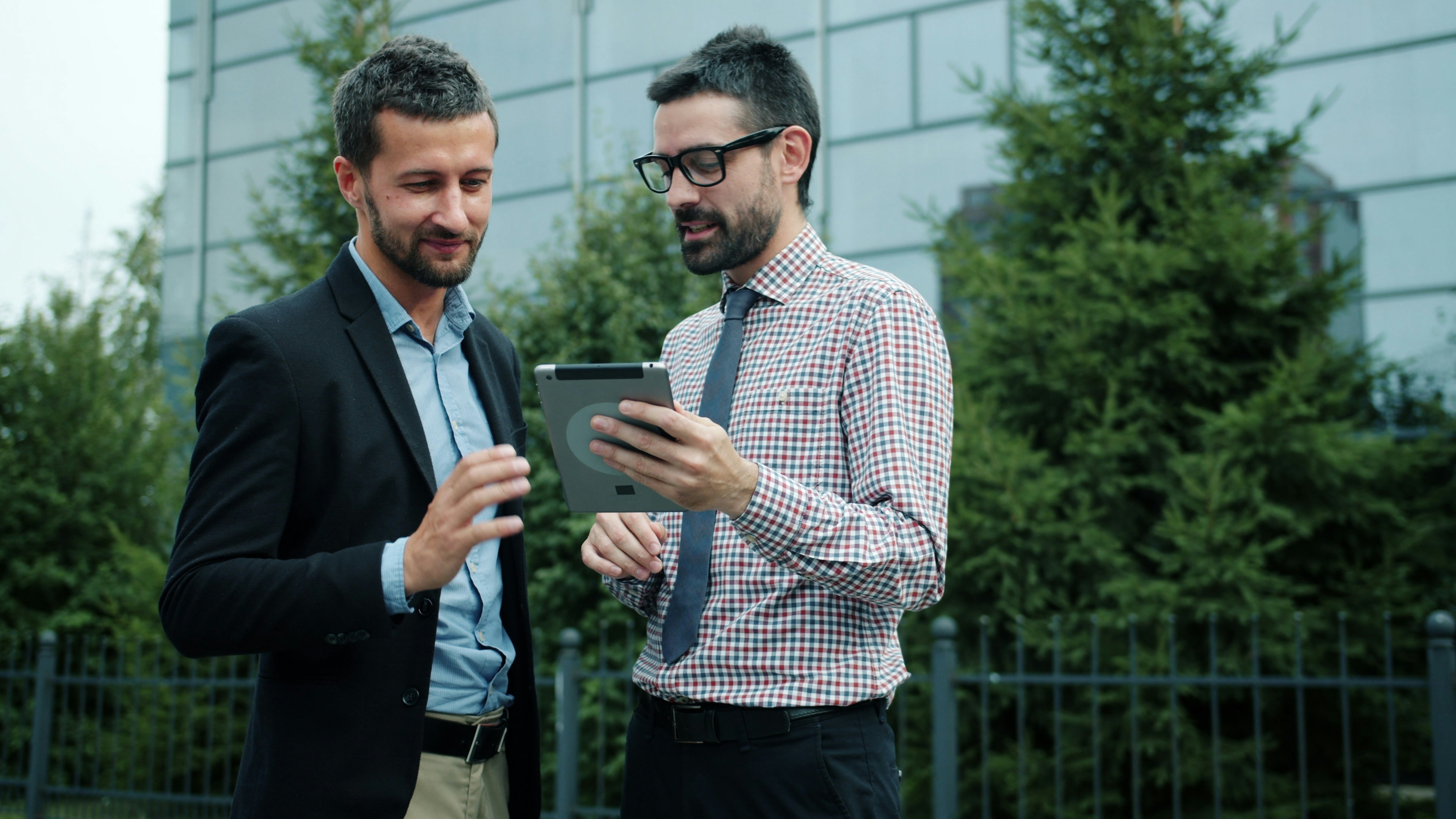 Businessmen using tablet outdoors