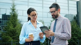 Two colleagues discussing a tablet outdoors