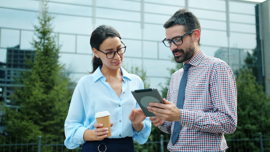 Two colleagues discussing a tablet outdoors