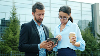 Two business people looking at a tablet outside.