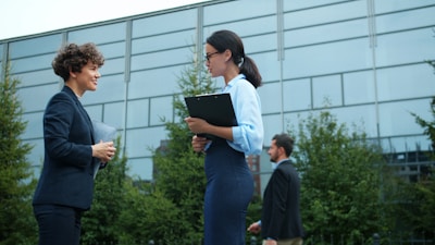 Two businesswomen talking outside modern building
