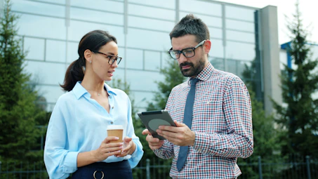 Two business people looking at a tablet outdoors