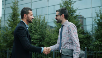 Two businessmen shaking hands outside an office building