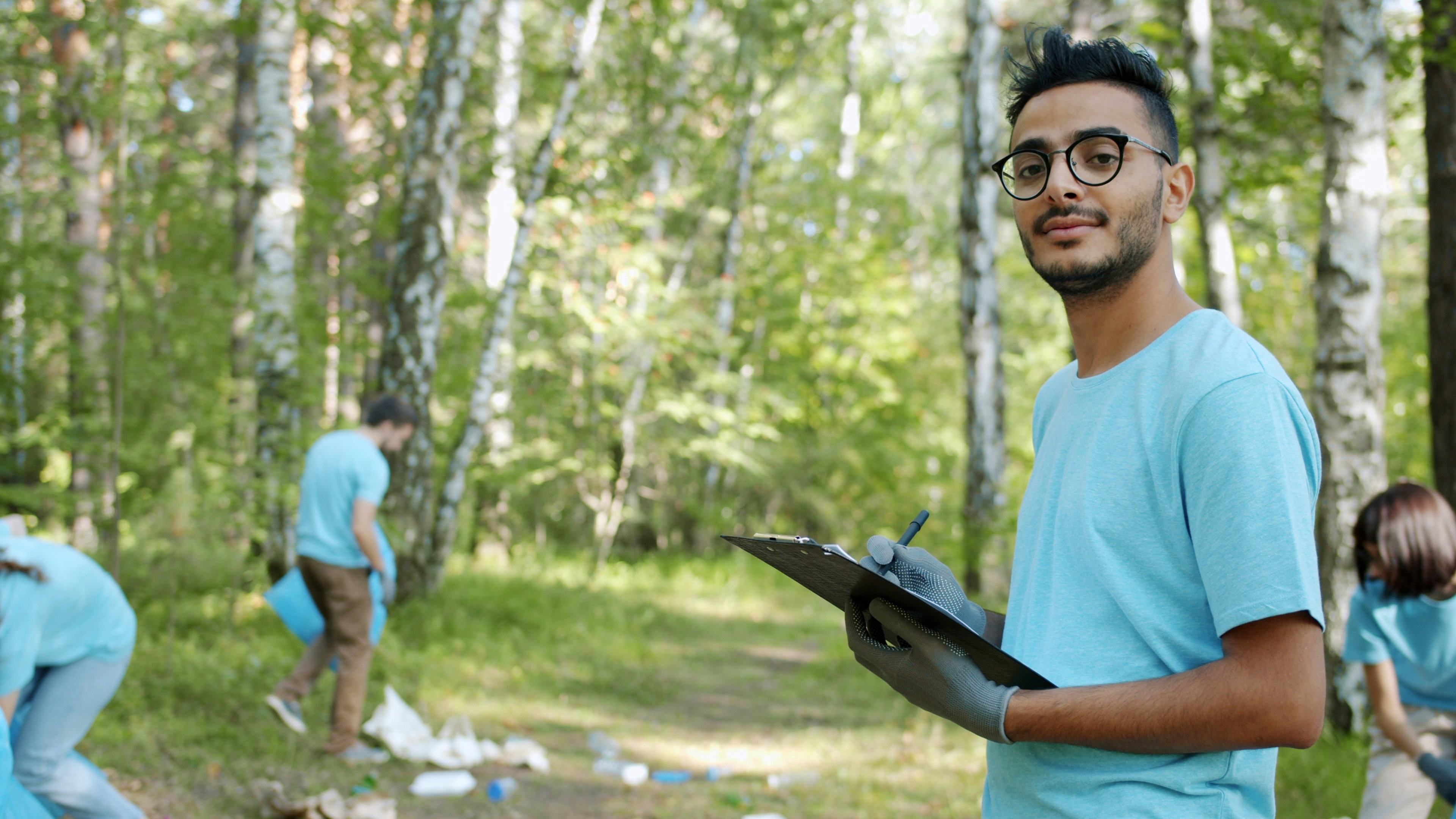 Man with clipboard in a park cleanup