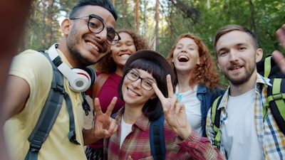 Group of friends taking a selfie in a forest.