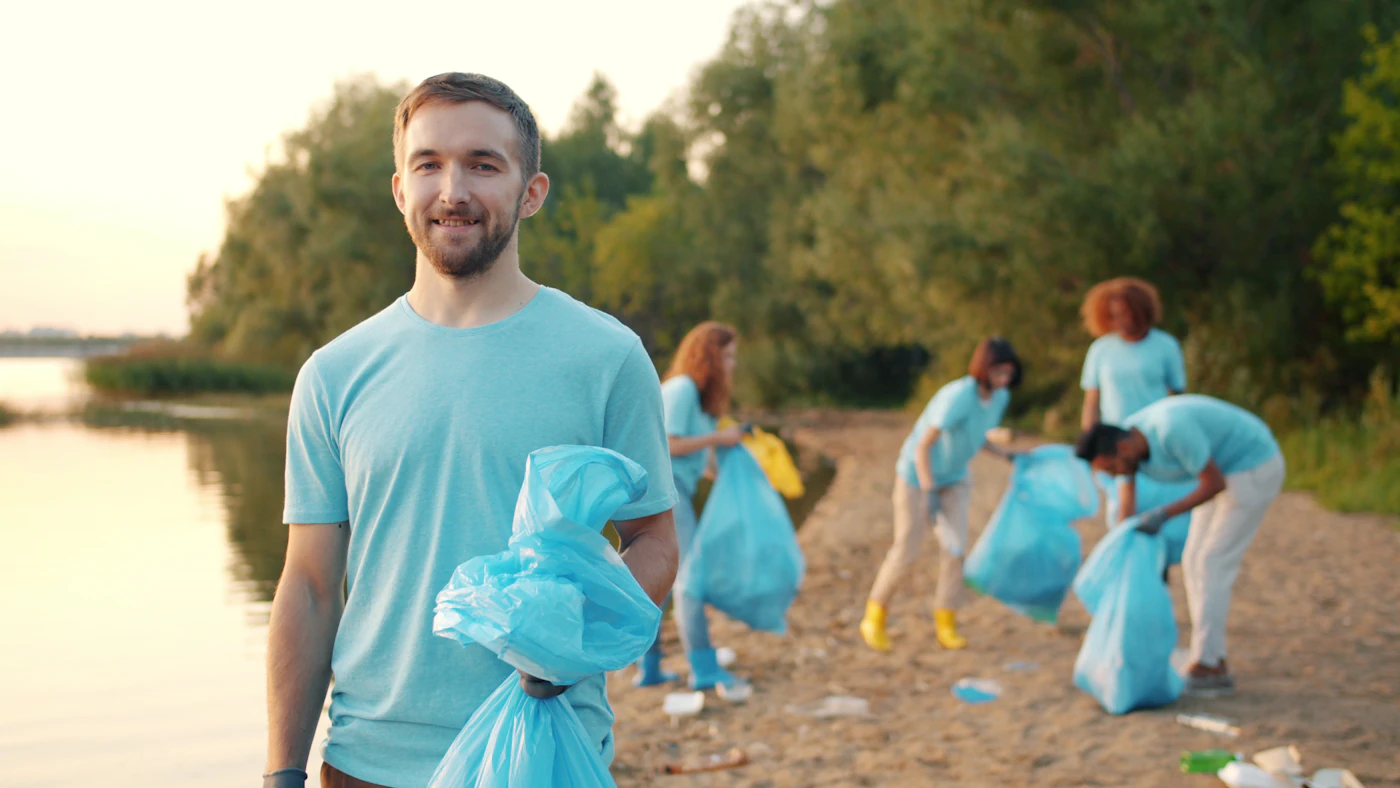 A volunteer holding a trash bag at a cleanup