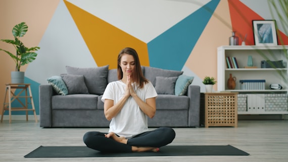 Woman meditating in lotus pose on yoga mat