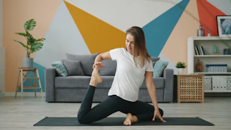 Woman practicing yoga on a mat in a living room.