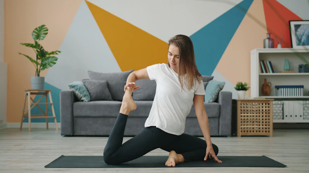 Woman practicing yoga on a mat in a living room.