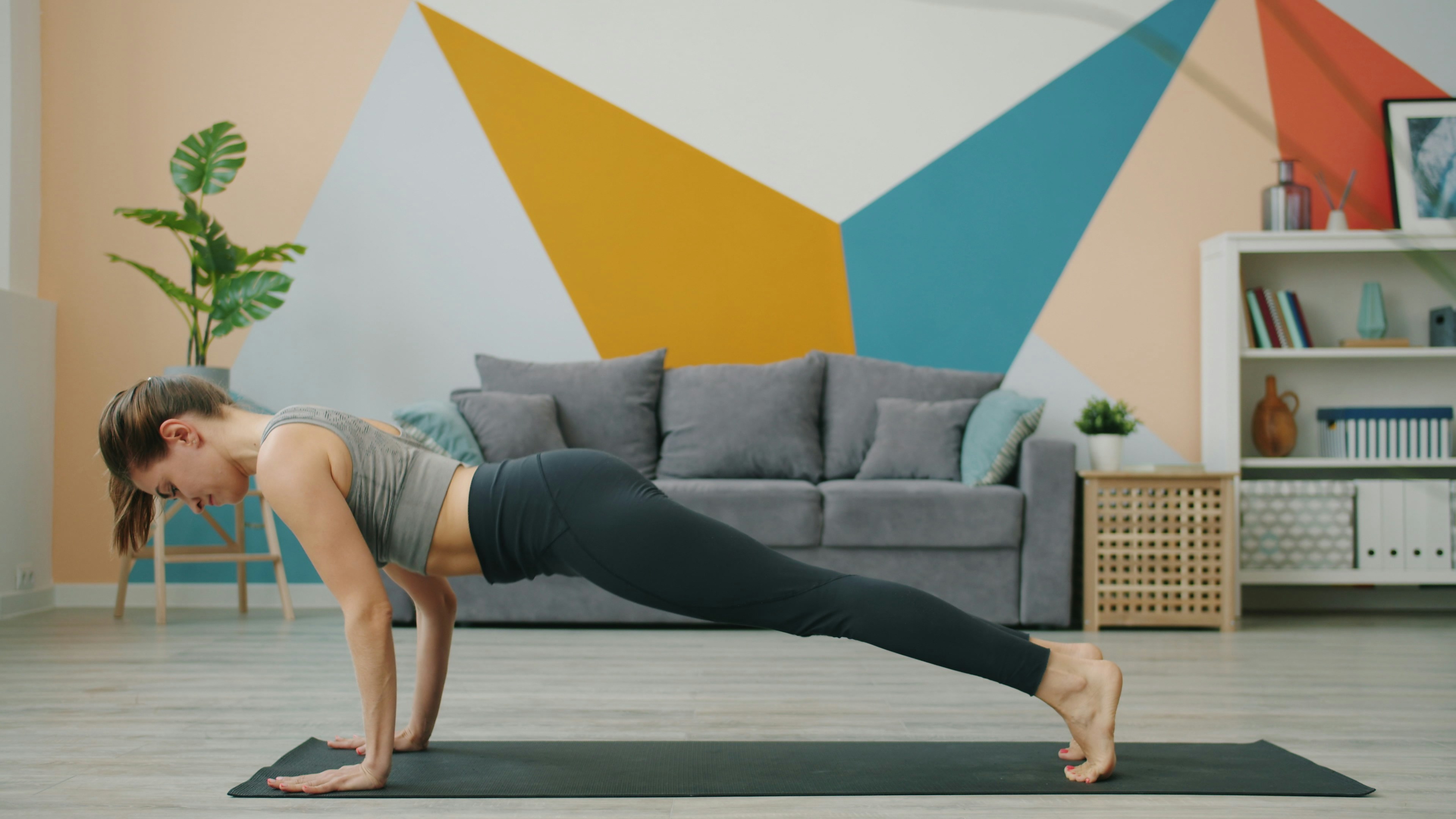 ผู้หญิงกำลังทำท่าแพลงก์บนเสื่อโยคะ