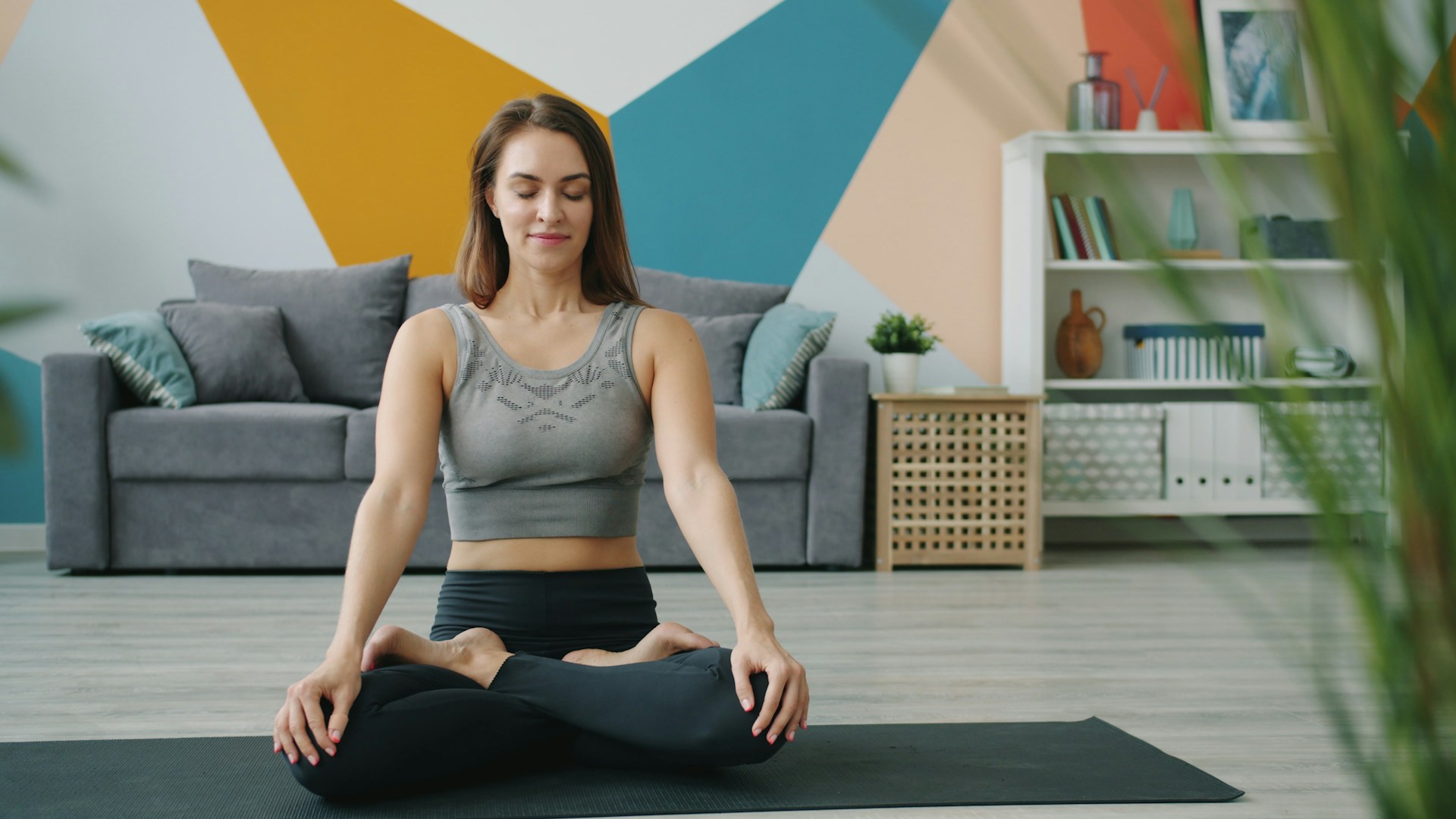 Woman meditating in a lotus pose on a mat.