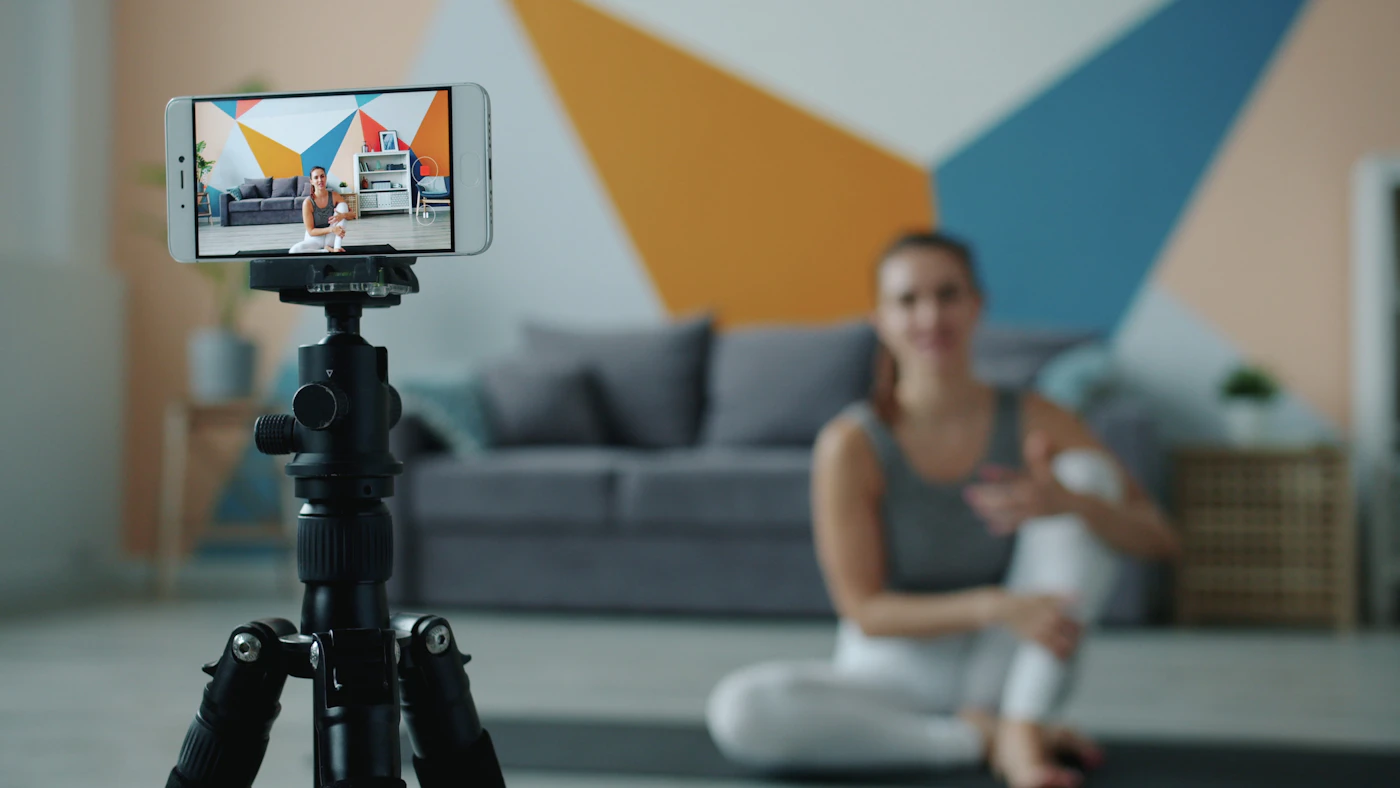 Content creator filming fitness content on a smartphone tripod