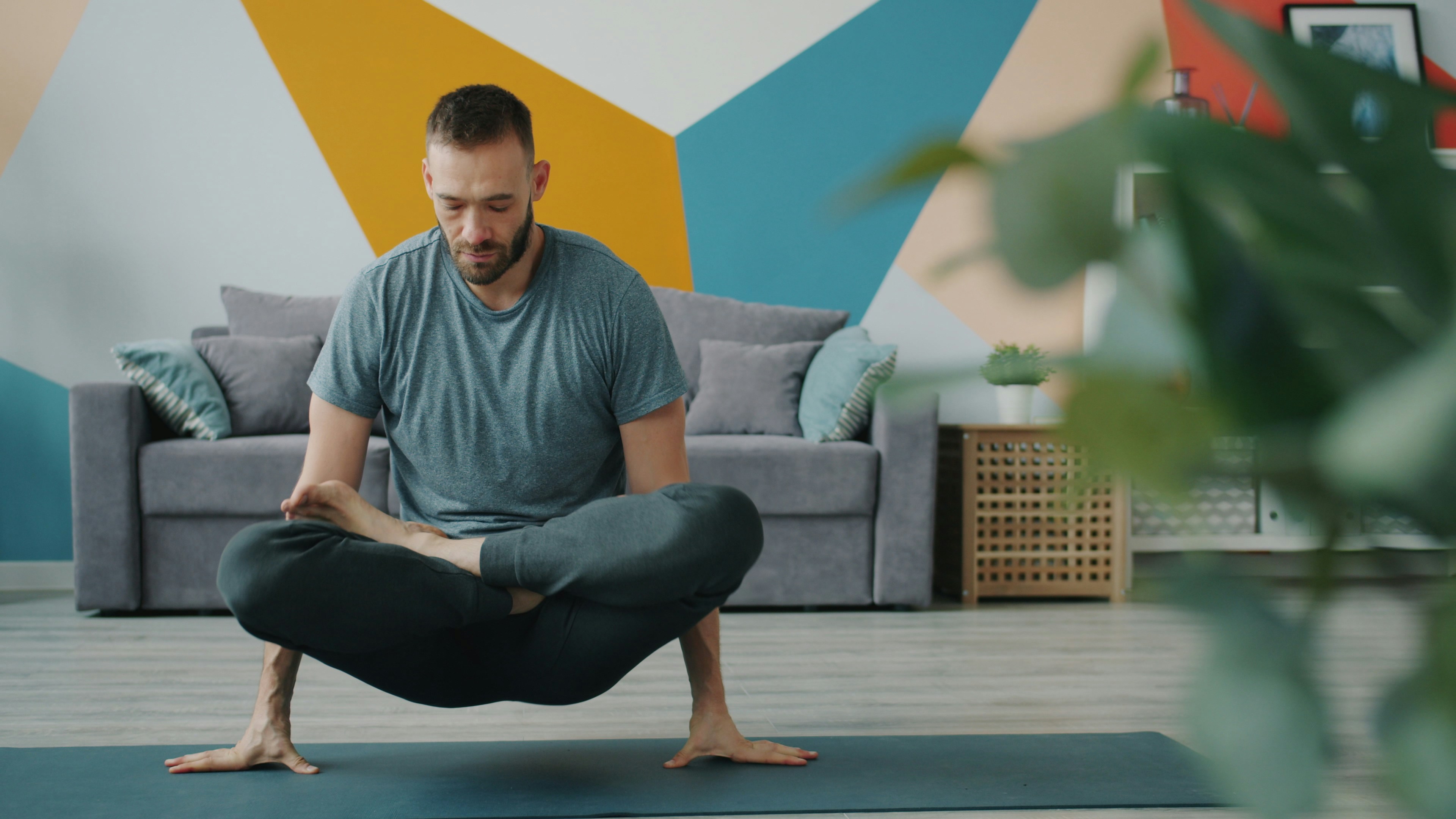 Man practicing yoga on a mat indoors.