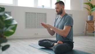 Man meditating in a bright, minimalist room.
