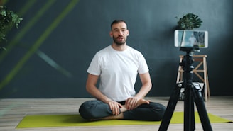 Man meditating in front of a phone camera