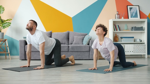 Couple doing yoga cat-cow pose at home