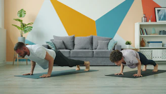 Man and woman doing push-ups on yoga mats.