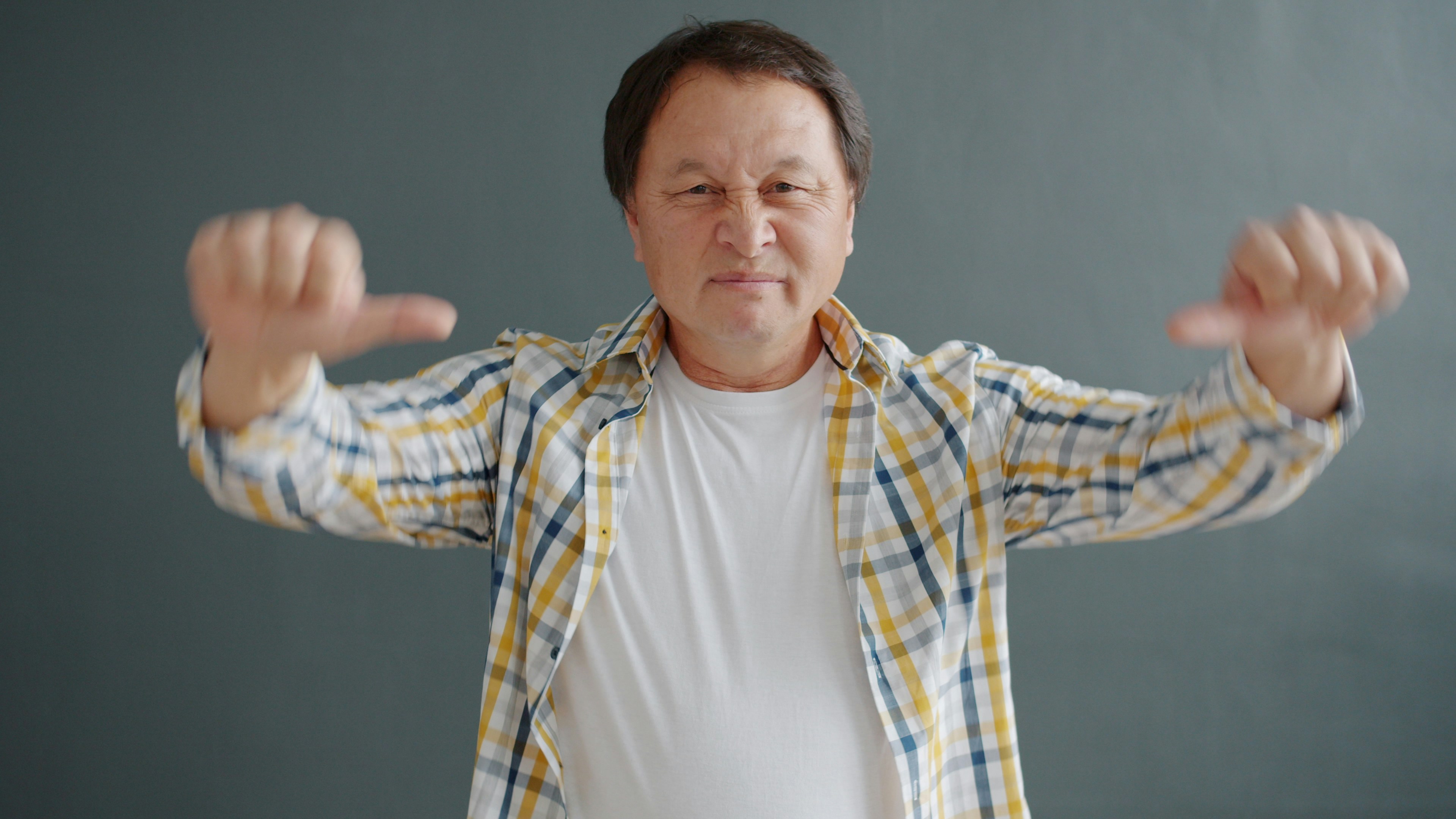 Mann zeigt mit beiden Händen eine Daumen-runter-Geste.