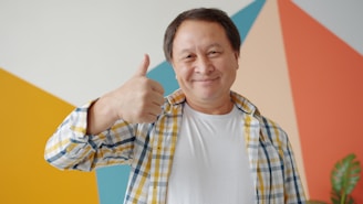 Smiling man gives a thumbs up gesture.