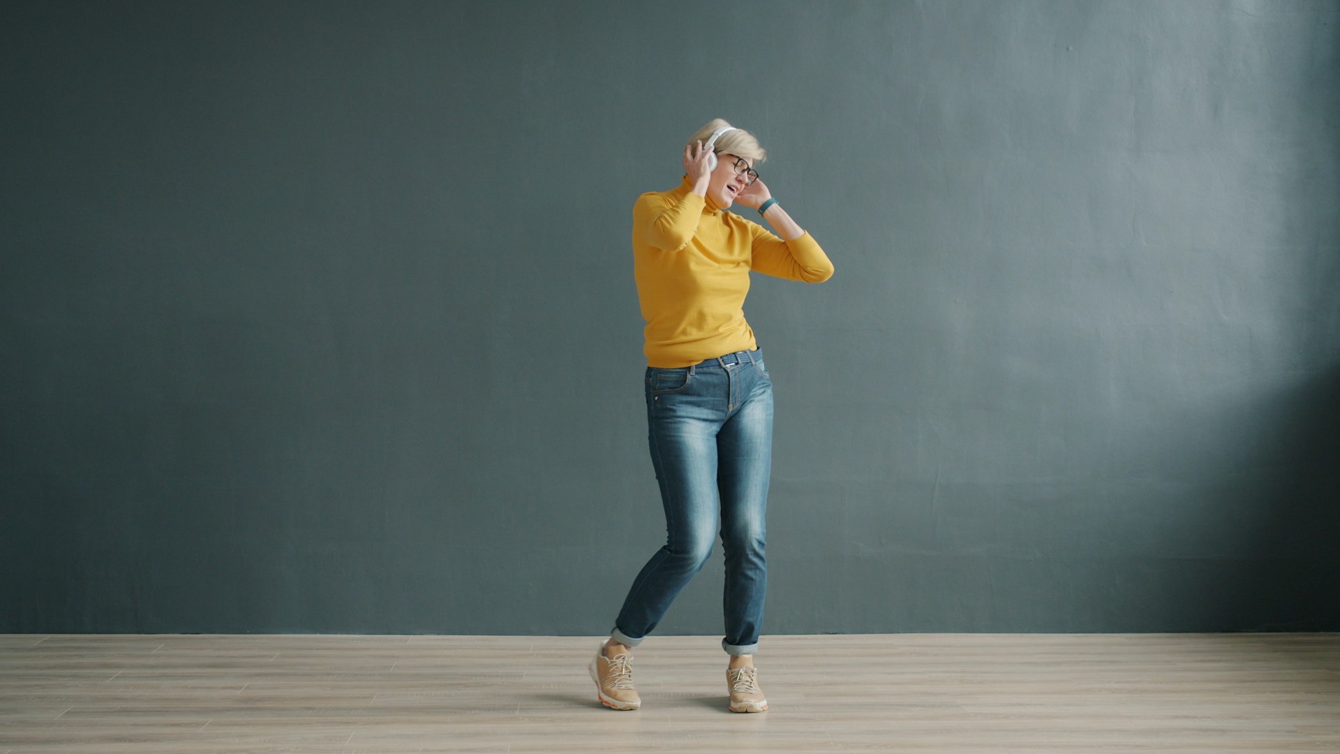 Woman in yellow shirt and jeans dancing