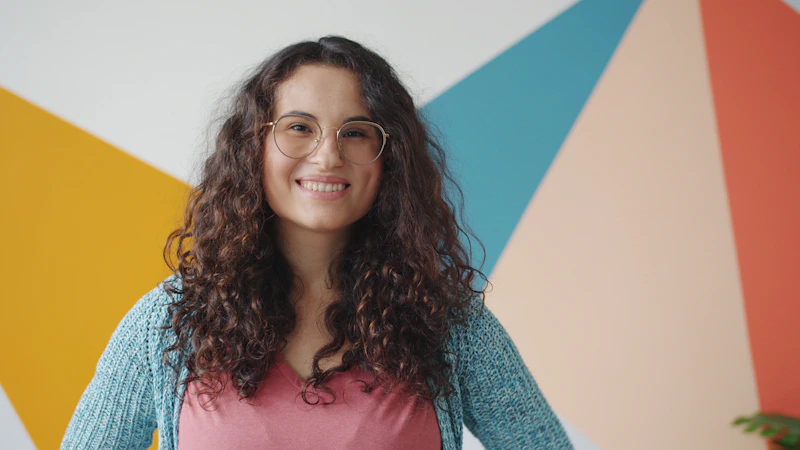 smiling woman with curly hair and glasses