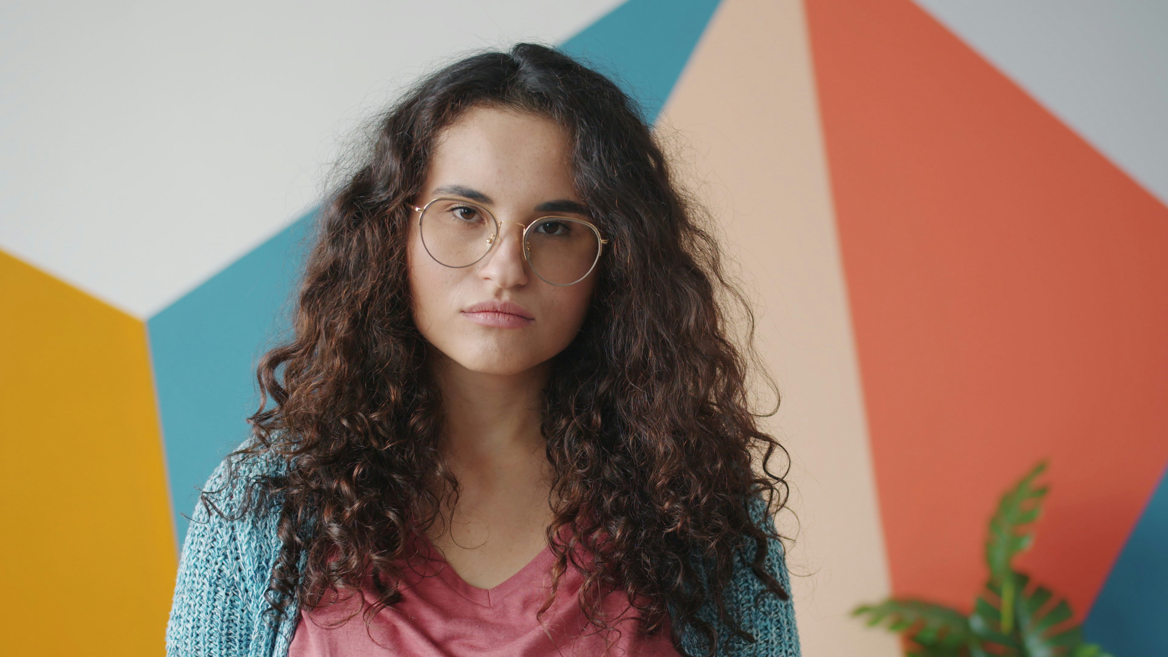 Young woman with curly hair wearing glasses