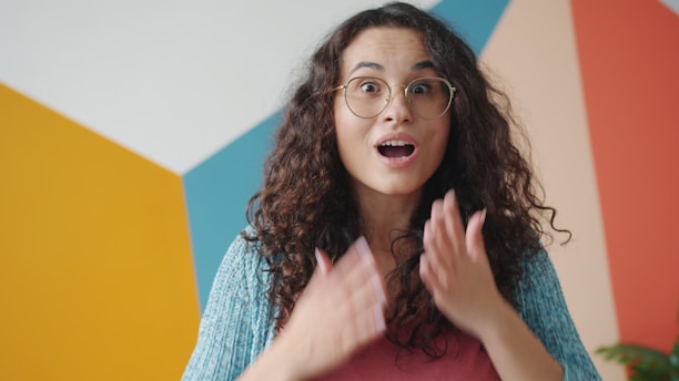 Young woman with curly hair looks surprised.