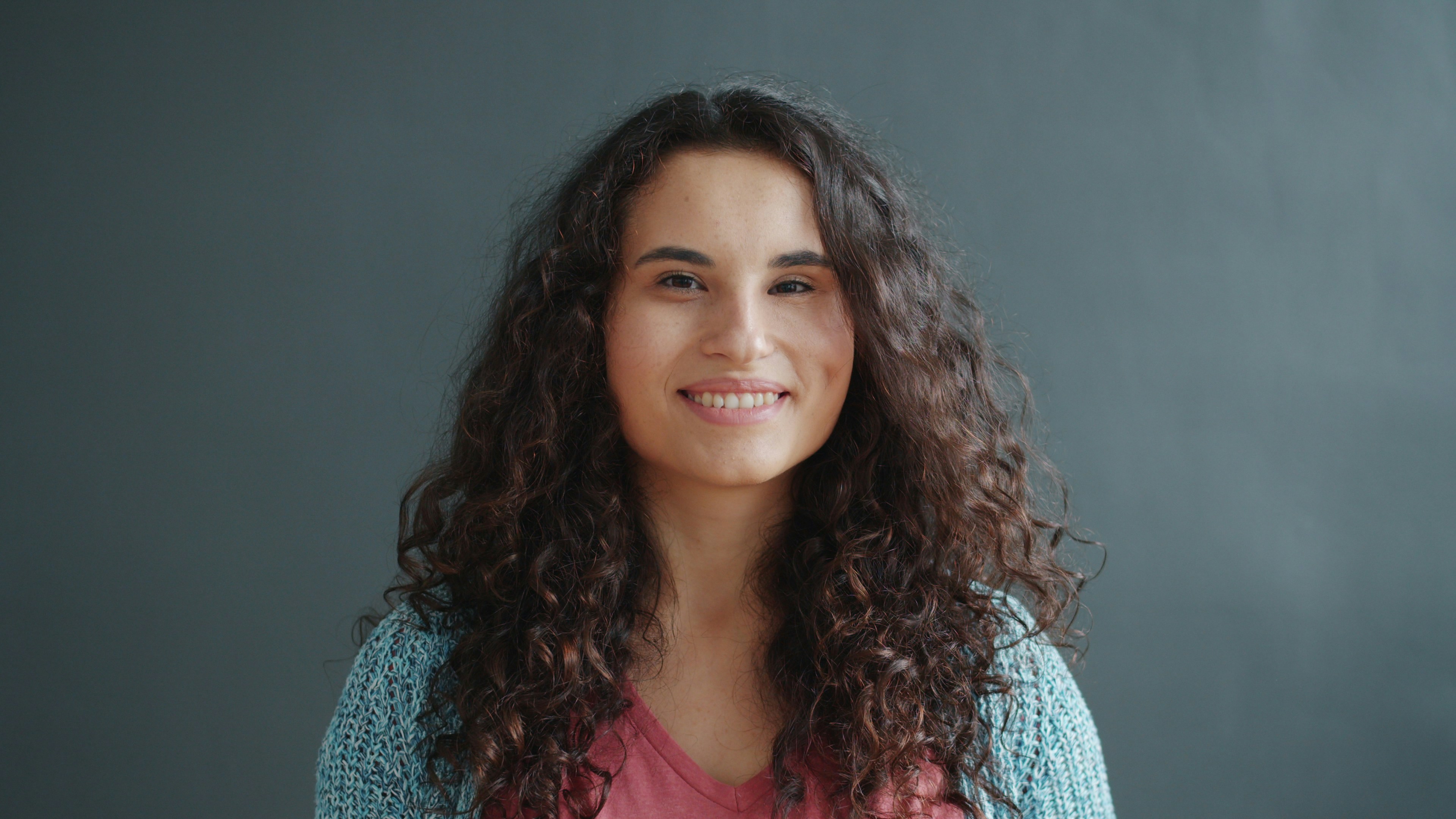 A young woman with curly hair smiling