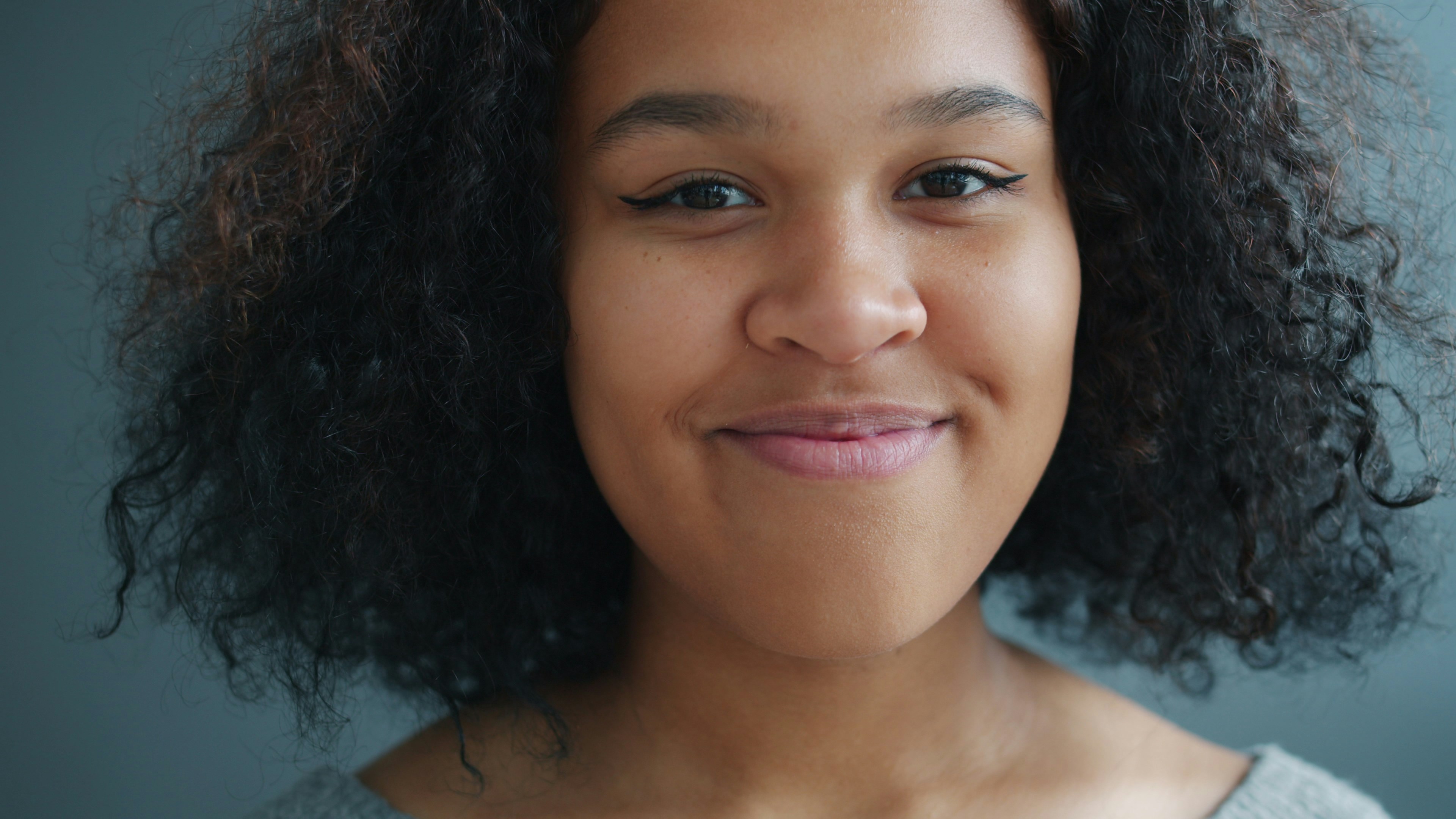 Young woman with curly hair smiling gently
