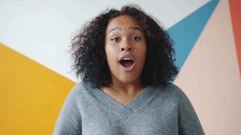young curvy woman with surprised look colorful background