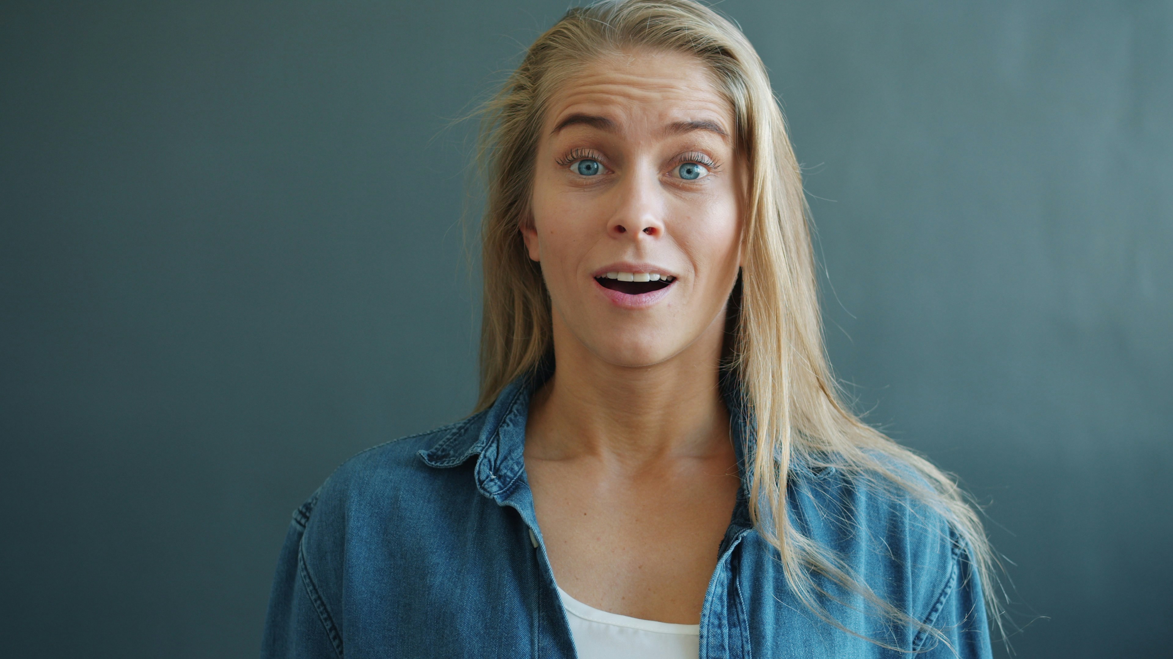 Surprised young woman with wide eyes and open mouth.