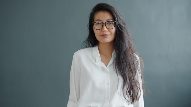 Woman with glasses wearing a white shirt.