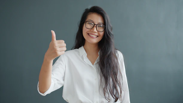 Woman with glasses gives a thumbs up