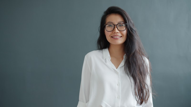 Woman with glasses smiling confidently