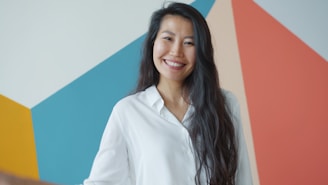 Young woman smiling in front of colorful geometric wall