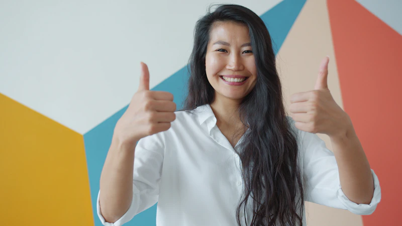 smiling woman giving two thumbs up