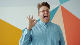 Man in blue shirt makes ok gesture with mouth open