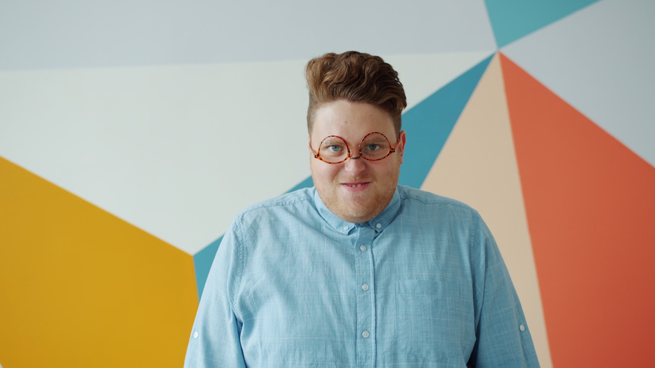 Person posing against a vibrant colorful backdrop for creative portrait photography